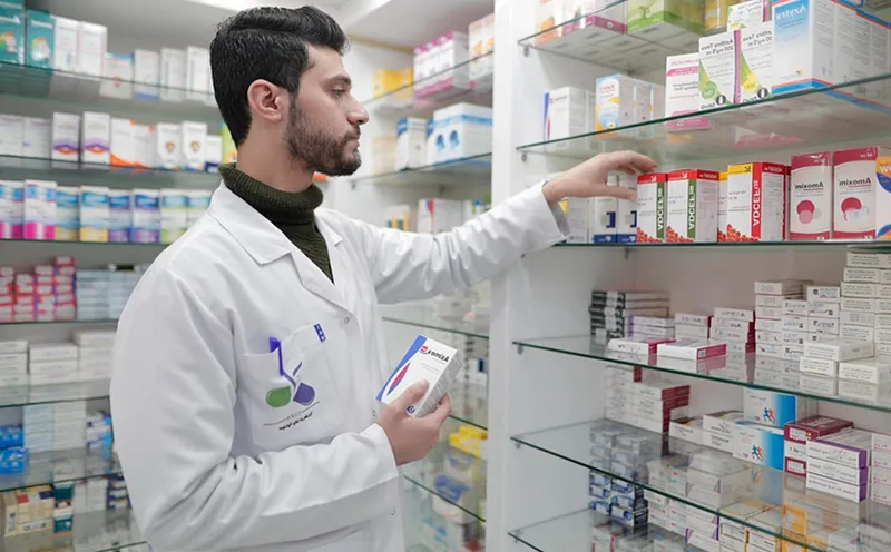 Farmacéutico organizando medicamentos en estantería